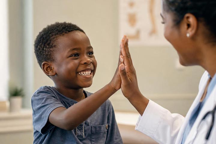 Doctor with young patient giving high-five.