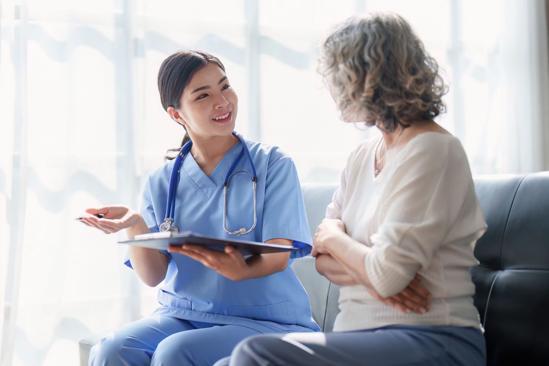 Physician and patient seated in office talking.